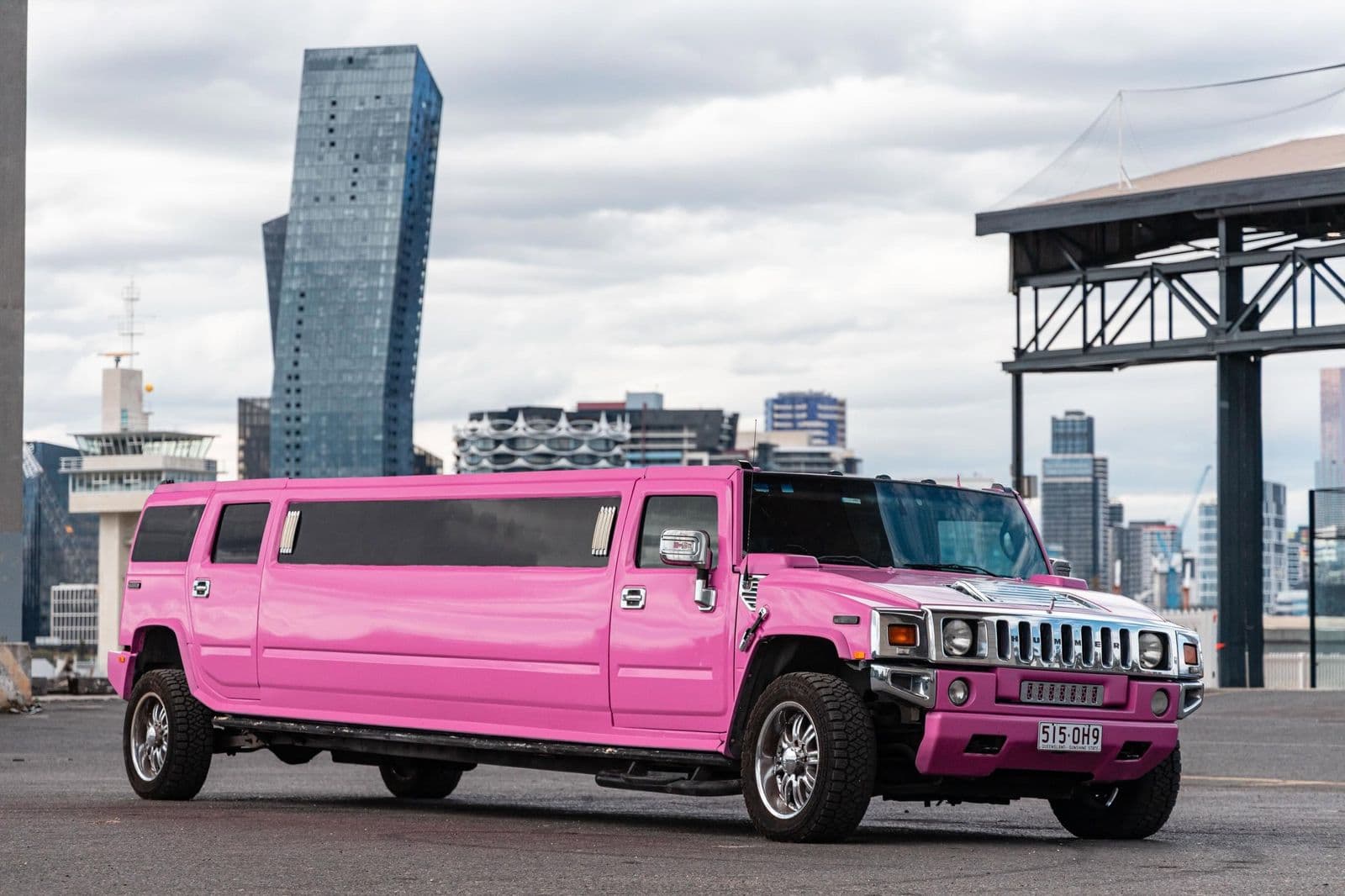 Pink Hummer stretch limousine with the Docklands skyline, Melbourne