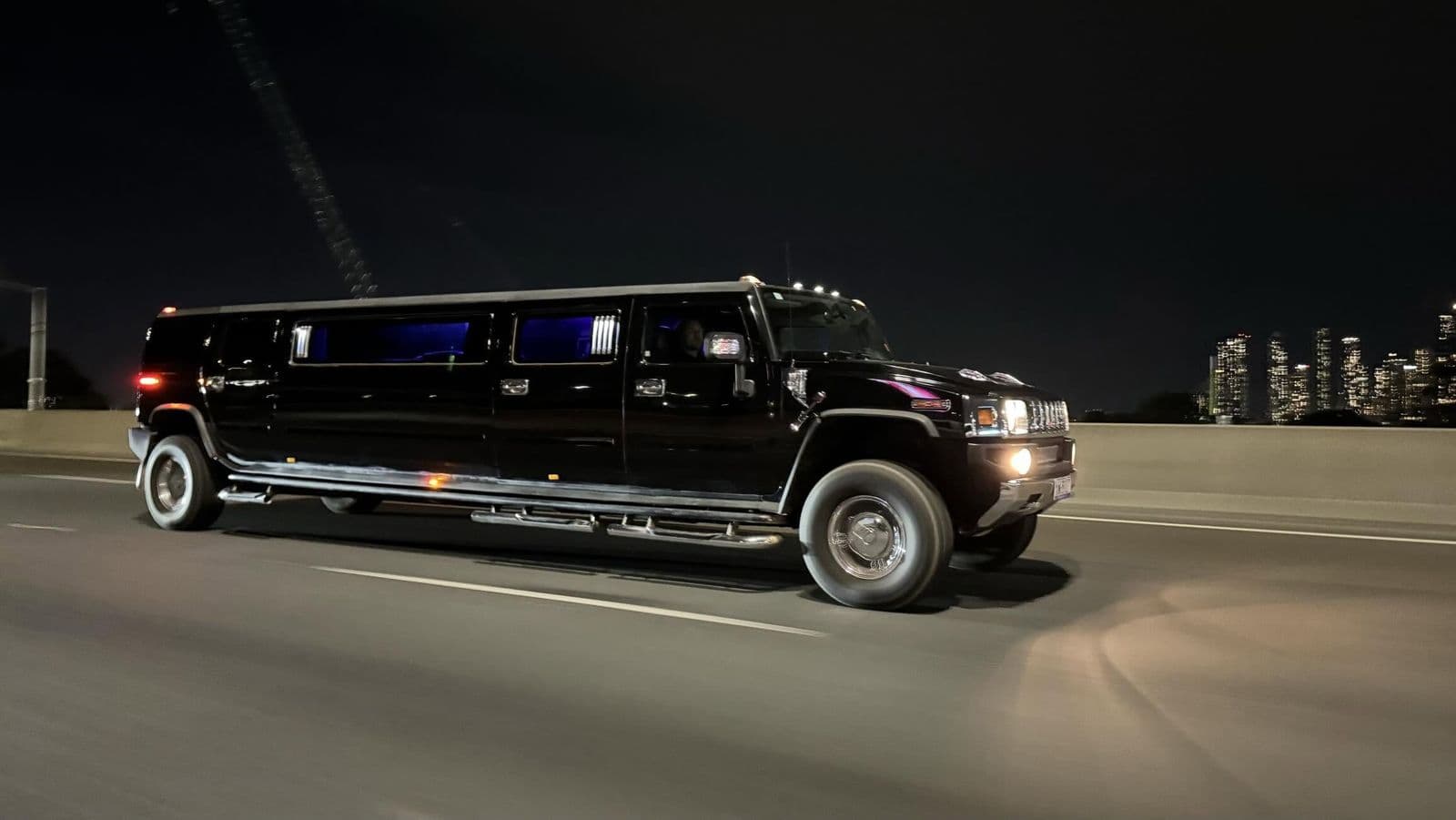 Black stretch Hummer limousine on a Melbourne freeway at night