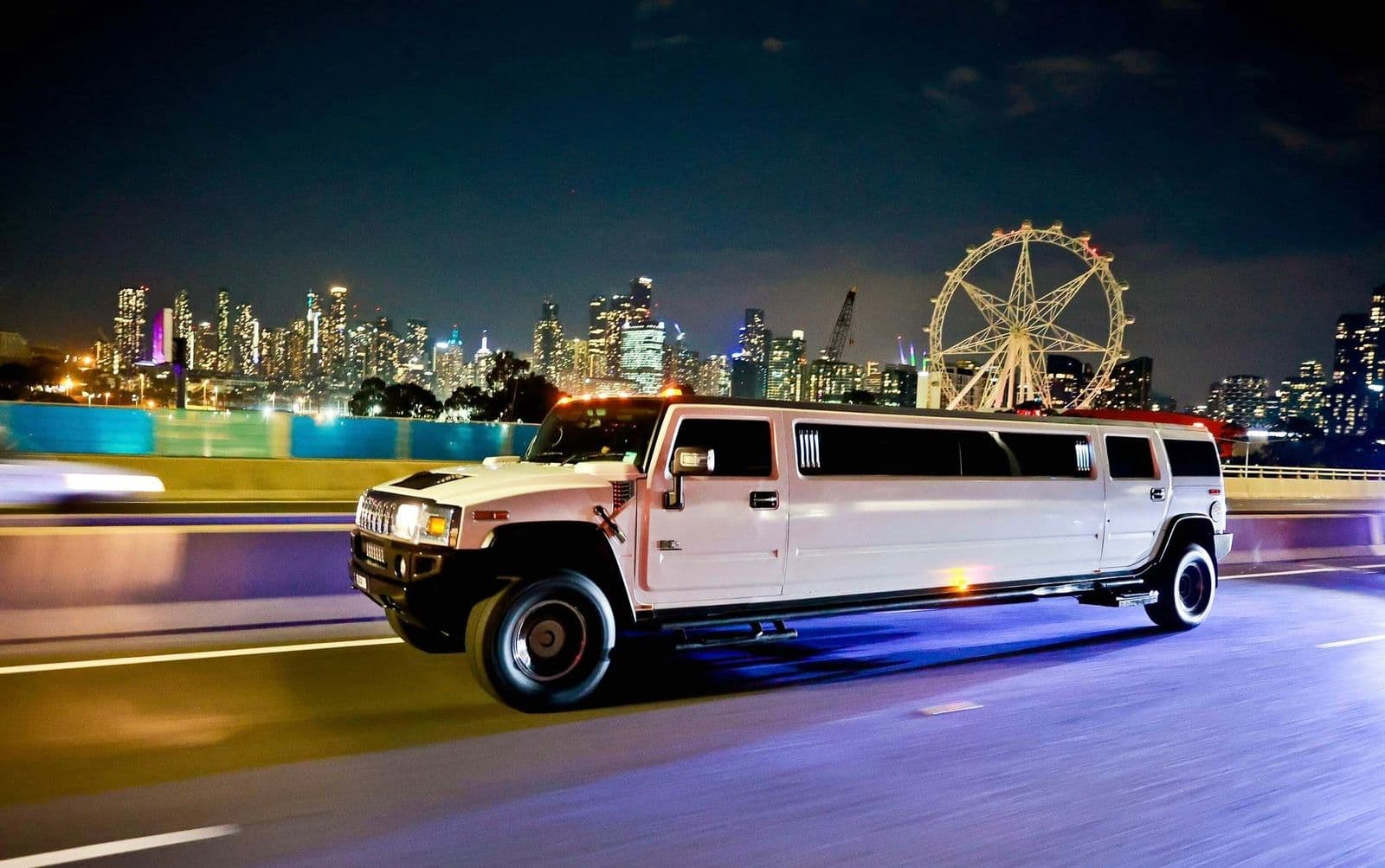White Hummer stretch limousine at night by the Melbourne Star